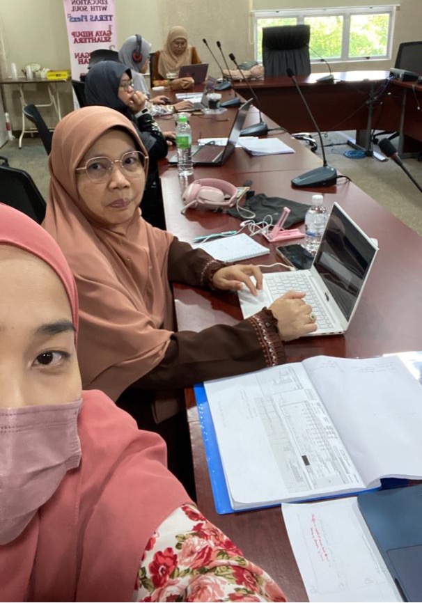 A group of women sitting at a table with a computer

Description automatically generated